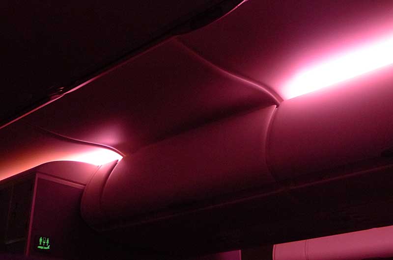 収納棚が夜間照明に照らされている美しいタイ国際航空の機内。