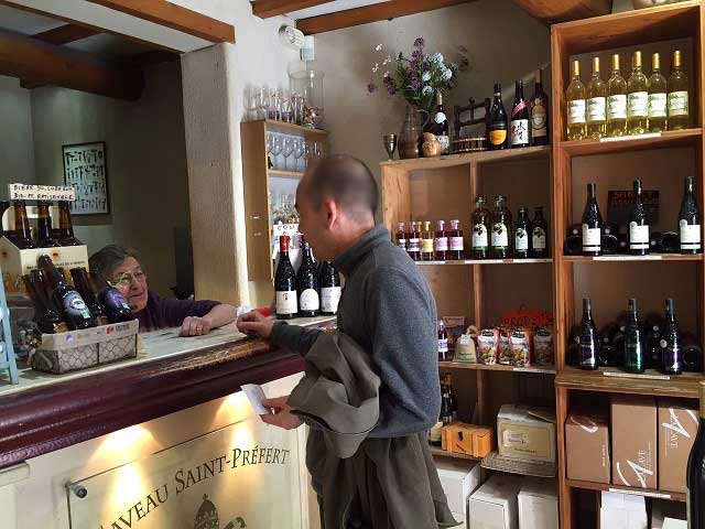 シャトーヌフデュパプの町にあるワインショップで、店主のおばあちゃんと話すラファエル
