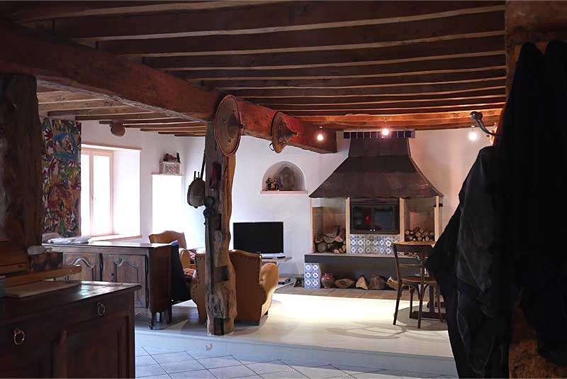 レースディーラーの自宅リビング。梁が見える天井と太い柱、アンティーク家具や大きな暖炉が見える。
